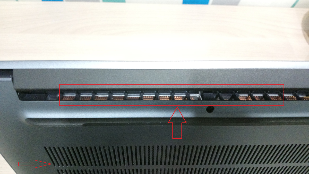 Красным обведены отверстия для выброса нагретого воздуха. Стрелка слева указывает на решётку, через которую засасывается холодный воздух.