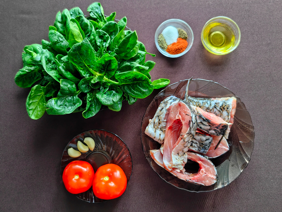 Продукты для приготовления сазана в сливочном соусе со шпинатом, помидорами и чесноком.