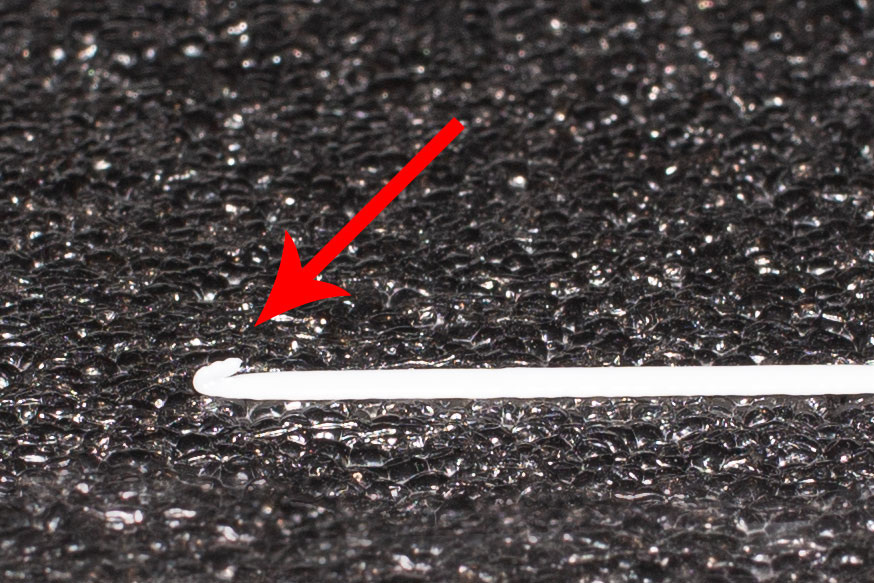 Если передний кончик линии филамента не лежит на столе, но задран, то скорее всего, нужно поднять стол винтами, или программно опустить голову принтера.