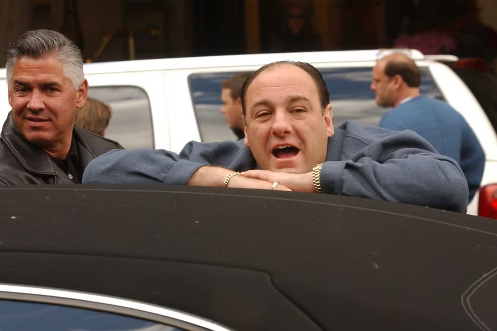 Джеймс Гандольфини в образе Тони Сопрано, стоит, прислонившись к машине, в ожидании начала съемок возле отеля Plaza.