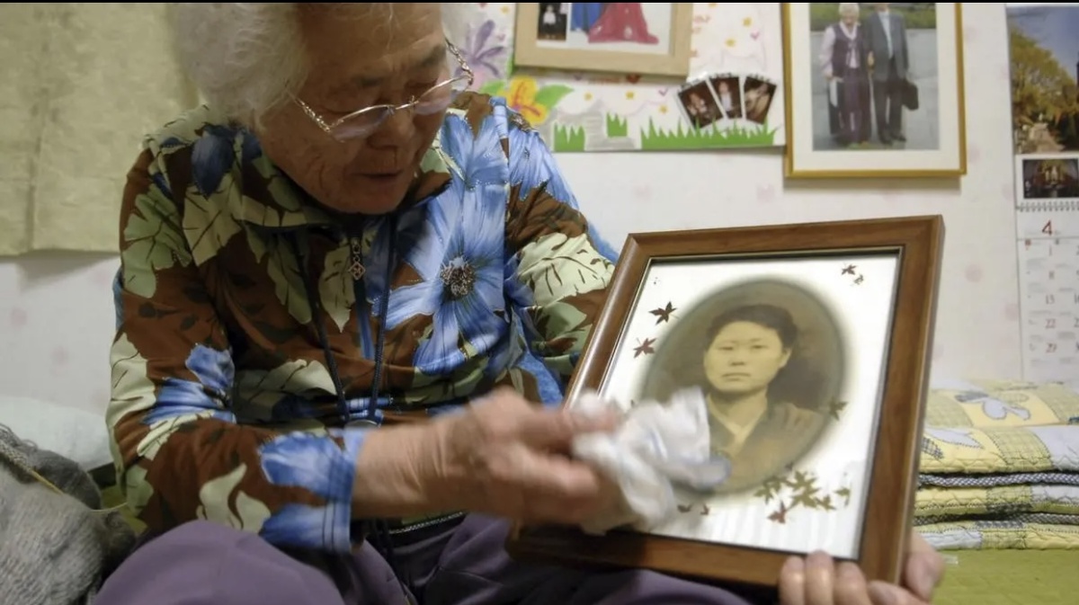 ЛИ ОК-СОН, ТОГДА 80 ЛЕТ, В ПРИЮТЕ ДЛЯ БЫВШИХ СЕКС-РАБЫНЬ НЕДАЛЕКО ОТ СЕУЛА, ЮЖНАЯ КОРЕЯ, ДЕРЖА СВОЮ СТАРУЮ ФОТОГРАФИЮ 15 АПРЕЛЯ 2007 ГОДА.