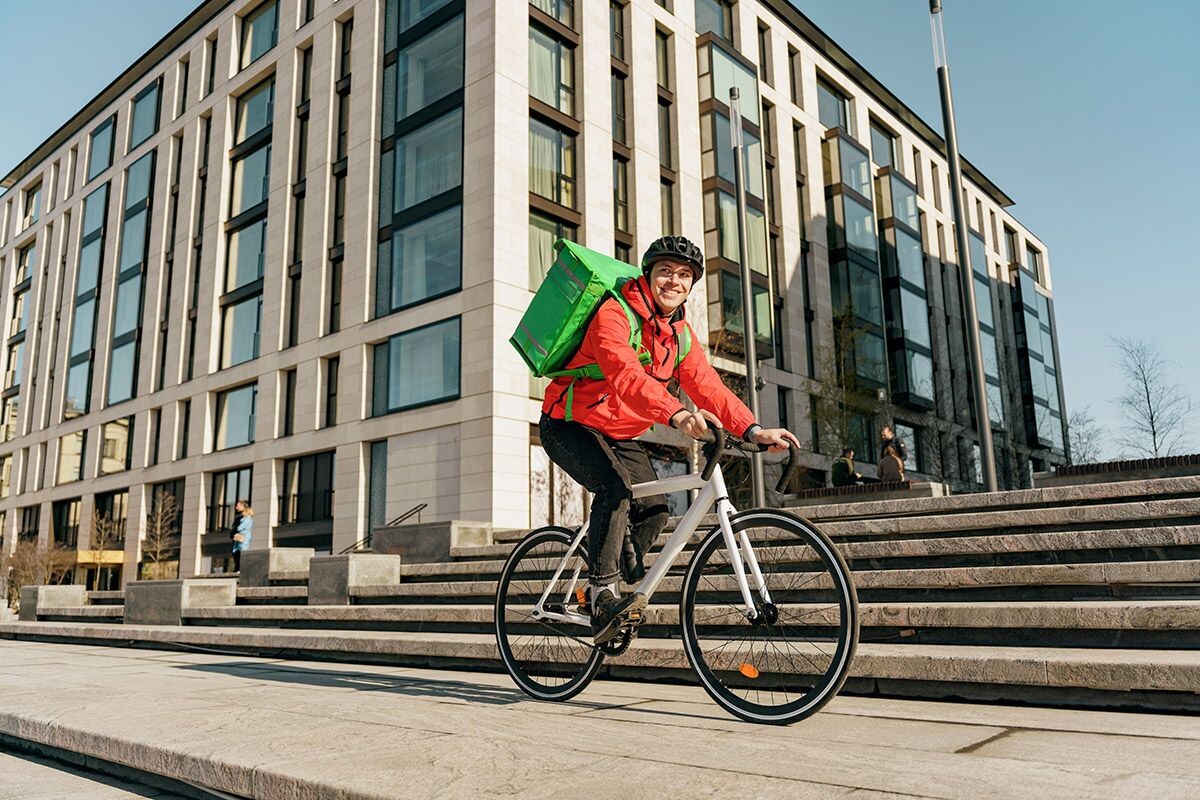 Курьера Delivery Club легко узнать по зеленой сумке за спиной. Источник: Shutterstock📷
