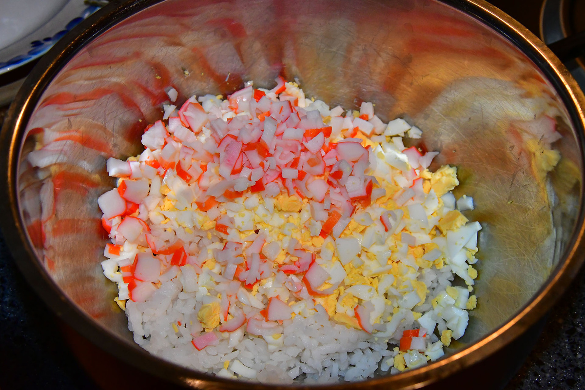 Выкладываем в миску яйцо, рис, крабовые палочки