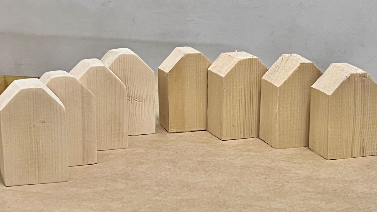 Справа заготовки из струганного бруса, слева шлифованные домики