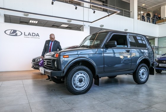    Посетитель осматривает автомобиль Lada Niva Legend в дилерском салоне Lada