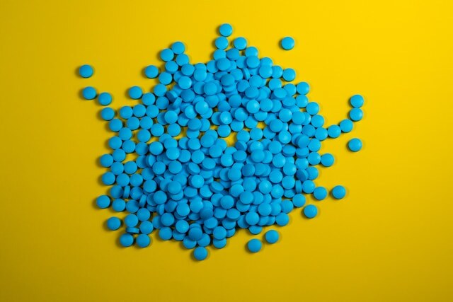 https://unsplash.com/photos/a-pile-of-blue-pills-on-a-yellow-background-pd0D_JCQx6E