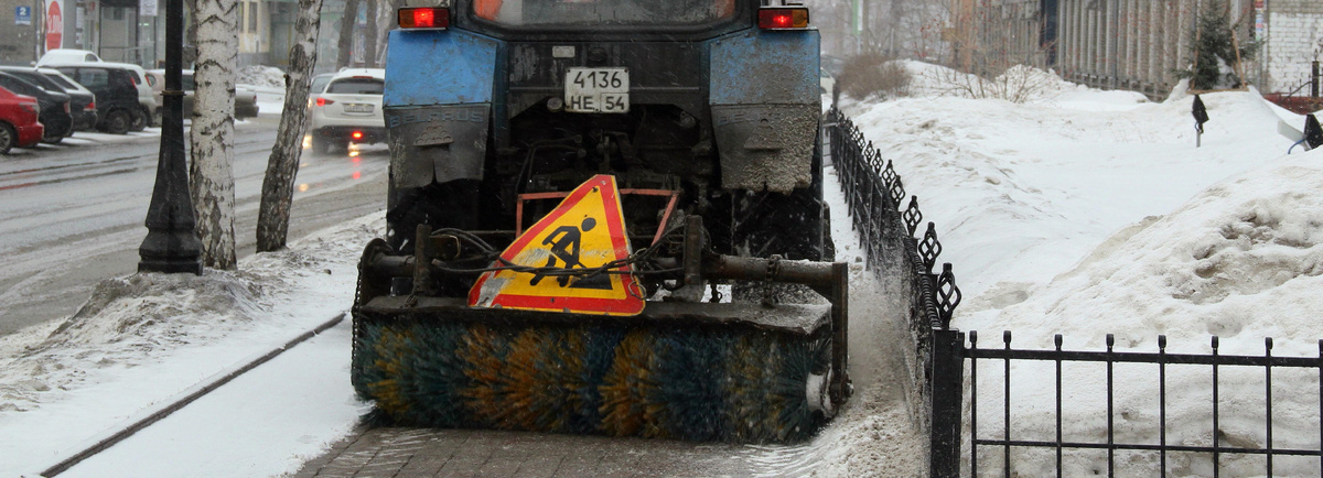 трактор чистит асфальт до ледяной корки