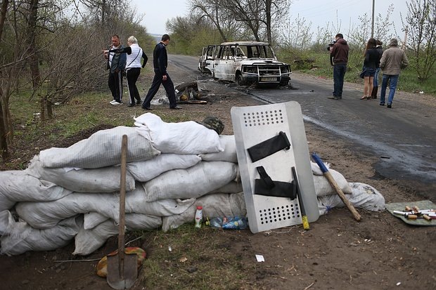    Сотрудники прокуратуры во время следственных действий на обстрелянном блокпосту у въезда в Славянск, 20 апреля, 2014 года. Фото: Михаил Почуев / ТАСС