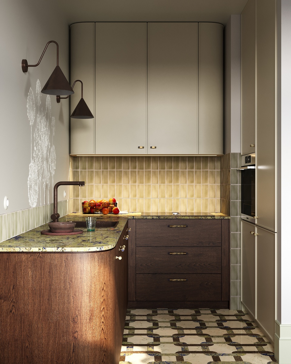 Рабочая зона расположена в углублении и состоит из угловой поверхности для готовки, верхних подвесных шкафов с закругленными по краям фасадами и высоких шкафов со встроенной техникой. Каждая деталь кухни здесь не случайна и помогает создавать необычную интерьерную историю: «десертная» коричневая и землистая гамма, глубокие оттенки дерева и светлые теплые тона для визуальной легкости, активная текстура столешницы и пола, округлые формы, изящный барельеф с растительным мотивом на стене, светильники-бра ретро-форм, смеситель и ручки на фасадах шкафов нестандартного оттенка. Все это создает умиротворение и индивидуальность в пространстве, где комфортно жить и интересно разглядывать предложенные дизайнером решения. 

Современные тренды 2025 года также подтверждают, что все больше людей устают от однотонной серо-белой гаммы и выбирают более сложные решения и теплые оттенки в интерьере.
