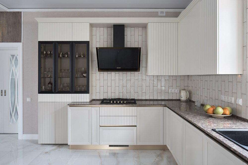 Фасады молочного оттенка удачно сочетаются с черными элементами и фурнитурой под золото