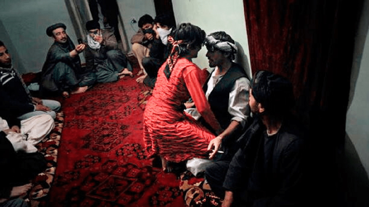 Бача-бази танцует в кругу афганских мужчин.