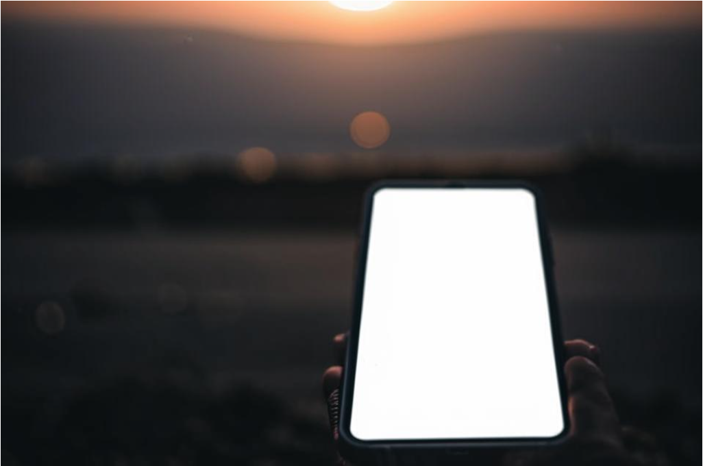 Фото пустого телефона с черным экраном на фоне утреннего света. Это может передать ощущение тревоги и растерянности.