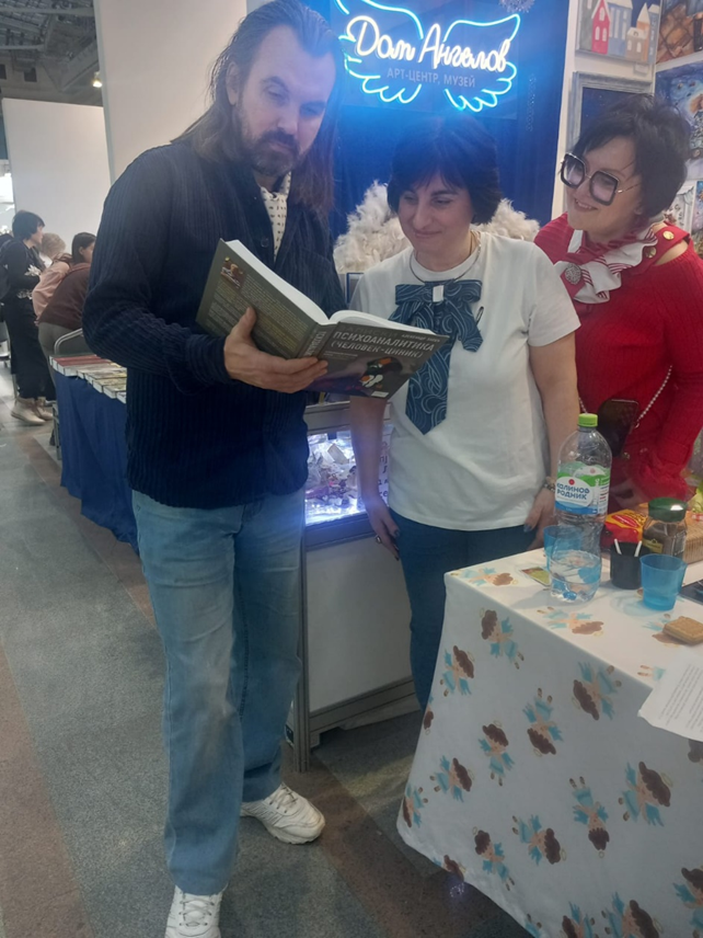 «Ажиотаж» на книжной выставке, посетители проявляют интерес к книге "Записки психоаналитика". Москва, Гостиный двор, 25.01.25