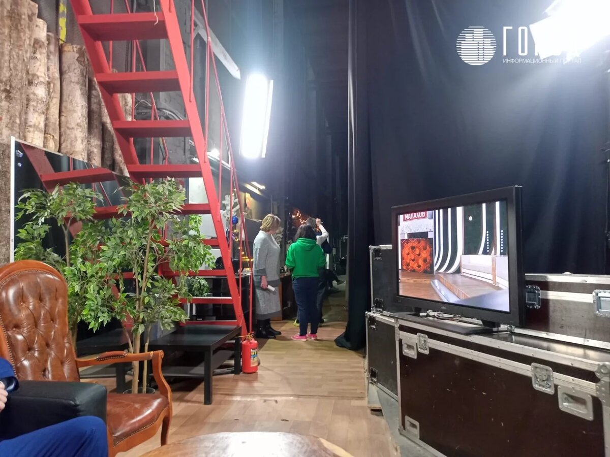 За кулисами.