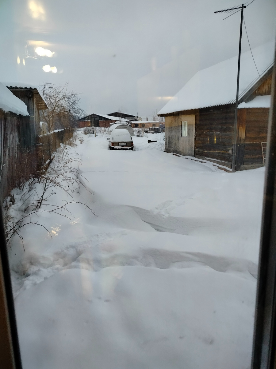 Вид из нашего окна на заснеженный двор соседей.