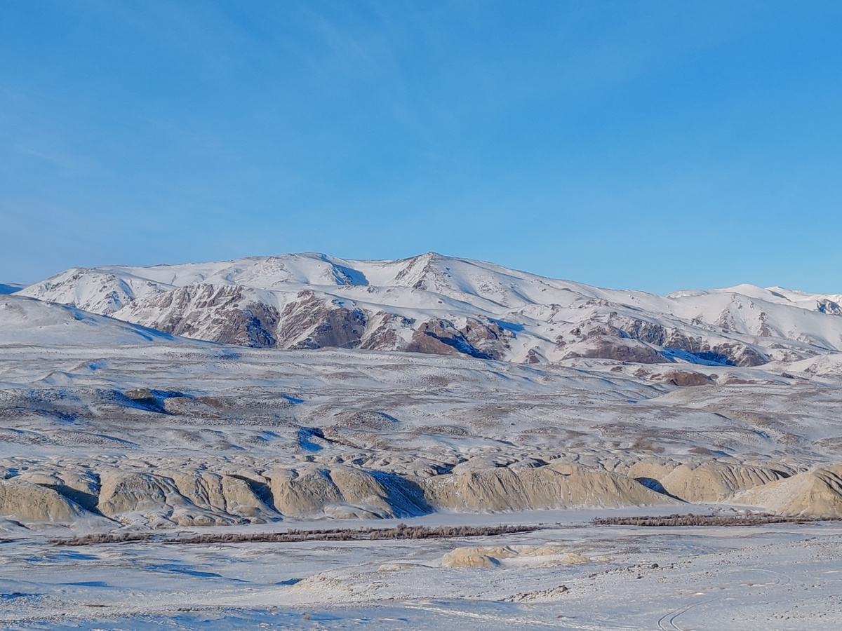 Горы выглядывают из под снега, летом красиво тут, они цветные