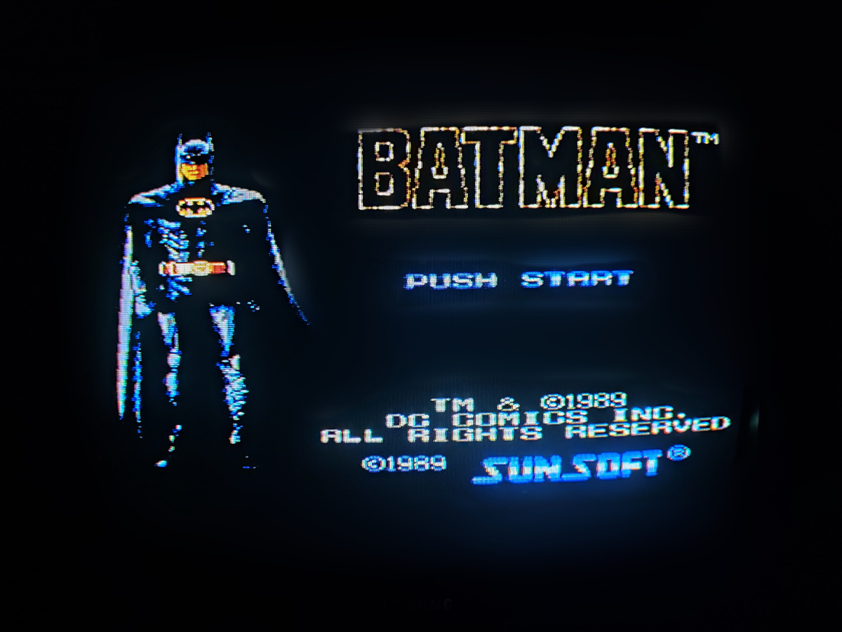 Фото сделаны мной. На фото игра Batman. Оригинал игры "Batman: The Video Game" был разработан и издан Sunsoft в 1990г. для NES. Геймдизайнеры Кадзутомо, МориМасаюки Такацудзи, Норико Сакаи,Тадаши Кодзима, Ёсиаки Ивата. Фото демонстрирует начальную заставку игры, а так же общий визуальный фон игры. Подробнее об этом рассказано в статье. Все материалы принадлежат правообладателям и размещены исключительно в информационных целях.