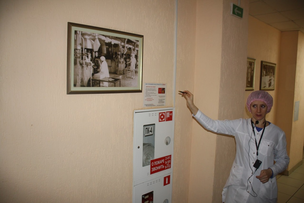 Экскурсовод у фото одного из первых цехов, рассказывает о том как производились конфеты в прошлом. Фото из экскурсии работников Гомсельмаша.