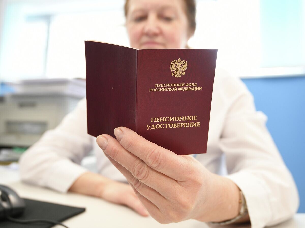 Сотрудник ПФР держит в руках пенсионное удостоверение© РИА Новости / Максим Блинов