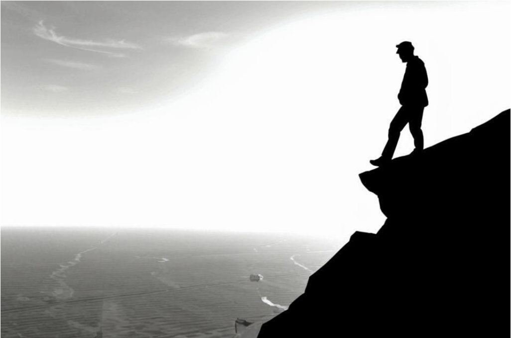 Человек стоит на обрыве с видом на далёкий горизонт, символизируя перспективу.