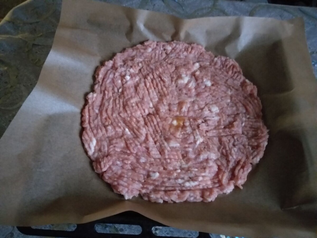 Размазать фарш по противню тонким слоем. Используйте антипригарный коврик.