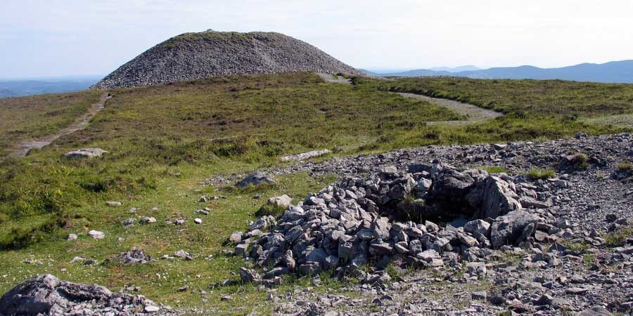 Курган Мэв. Голубая гряда слева - Бычьи горы недалеко от Круахана. В этих горах добывали кварц, которым была когда-то облицована гробница.