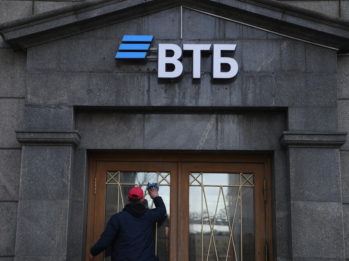    Сотрудник протирает стекла двери офиса "ВТБ" банка в Москве© РИА Новости / Алексей Майшев