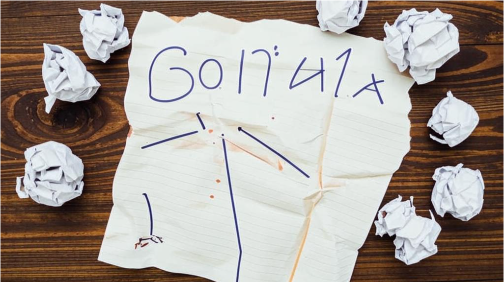 Рваный лист бумаги с написанными, но зачёркнутыми целями, лежащий на столе.