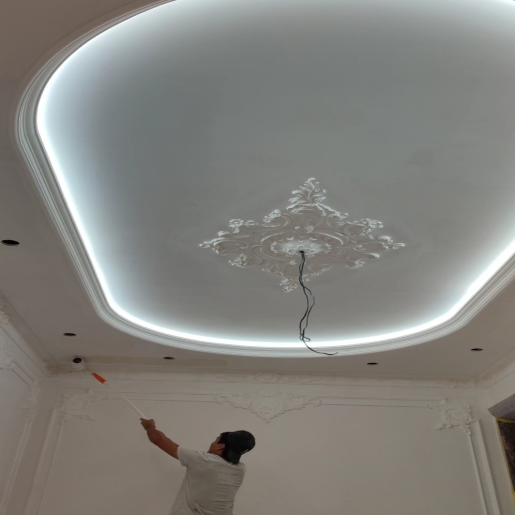 Когда он окунул валик в лоток с краской, он почувствовал тихое удовлетворение. Это была не просто очередная работа; это было искусство в процессе. Белая краска скользила по поверхности, плавно сливаясь с классическими деталями, которые придавали комнате очарование. Каждый мазок приближал пространство к завершению, превращая его из пустой оболочки во что-то великолепное.