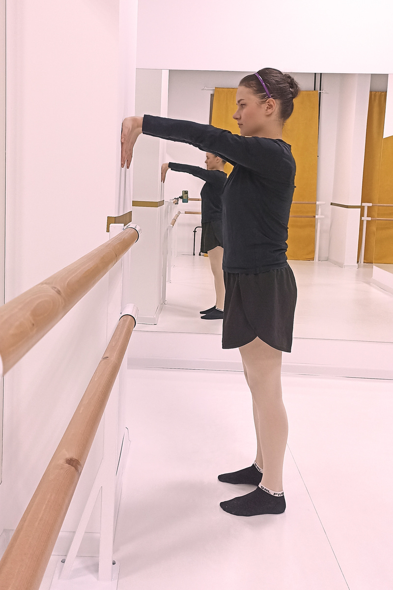 Встаньте лицом к стене. Поверните руки наружу и расположите ладони на стене пальцами вниз. Поднимите или опустите ладони в зависимости от комфортного натяжения в области предплечья. 