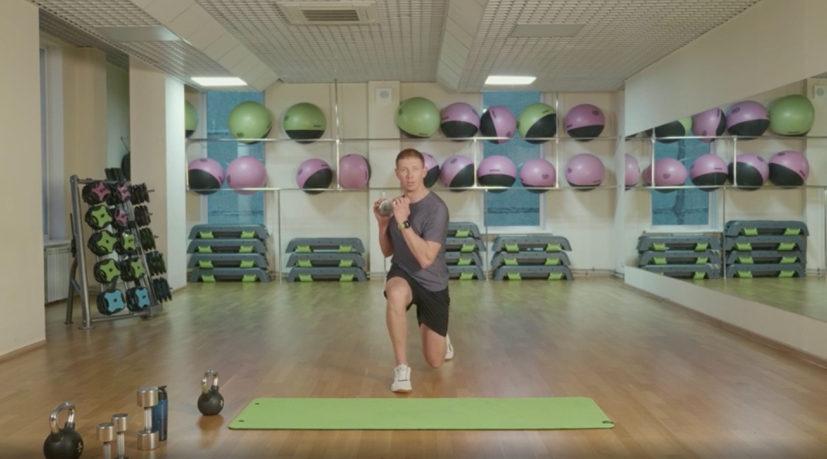 Выпад назад с ротацией грудного отдела с гантелей на груди