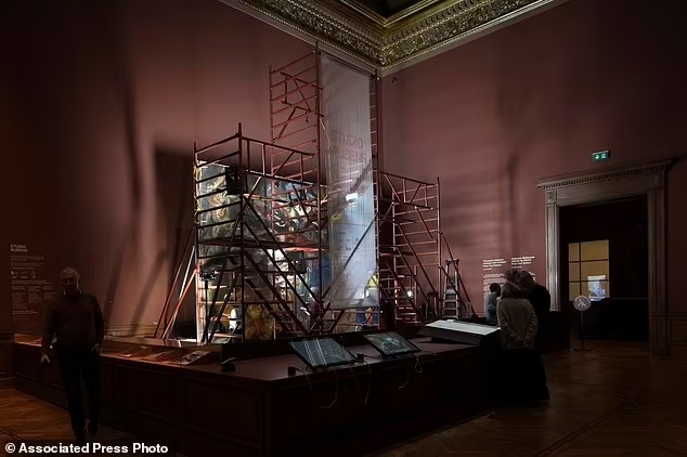 Посетители наблюдают за работой реставраторов над картиной «Мадонна в кресле, окружённая святыми», написанной фламандским художником Питером Паулем Рубенсом, в Королевском музее изящных искусств в Антверпене, Бельгия, среда, 15 января 2025 года.