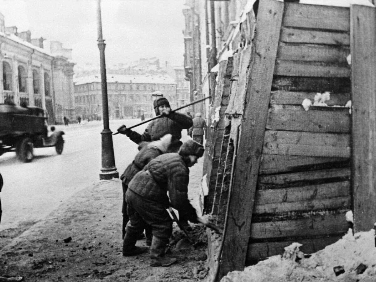    27 января 1944 года закончилась героическая оборона города на Неве, продолжавшаяся 872 дня. После снятия блокады Ленинграда, жители города снимают защитные укрытия с домов на Садовой улице. Слева здание Гостиного двора© РИА Новости / Борис Лосин