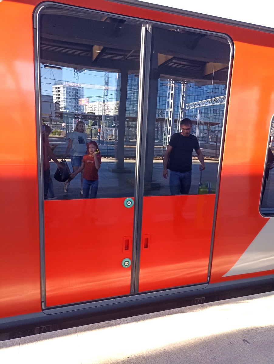 Видите большую зеленую кнопку? Вот она и открывает дверь. И на выходе из вагона тоже надо самому кнопку нажимать.