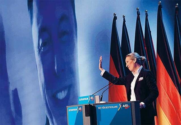    TASS/EPA: Сопредседатель партии АдГ Алис Вайдель во время выступления на предвыборном митинге партии приветствует генерального директора SpaceX и Tesla Илона Маска, дозвонившегося по видеосвязи