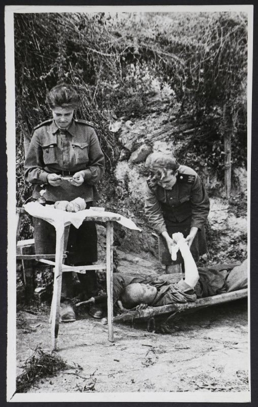    Малая земля. Старший лейтенант медицинской службы Б. Н. Родина и санинструктор В. Т. Смалько оказывают помощь раненому. 1943 год.