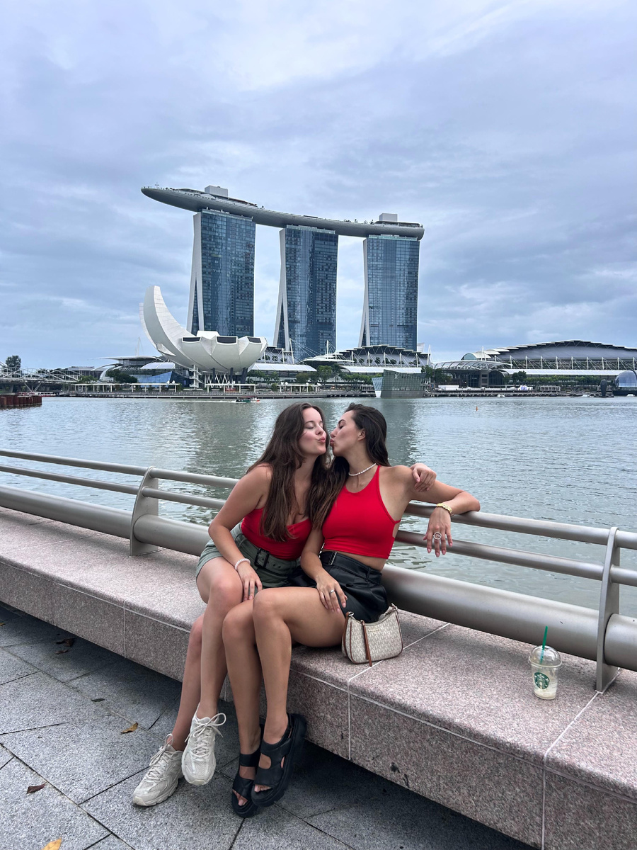 Дочки на фоне интегрированного курорта Марина Бей Сендс в центральном районе Сингапура. 