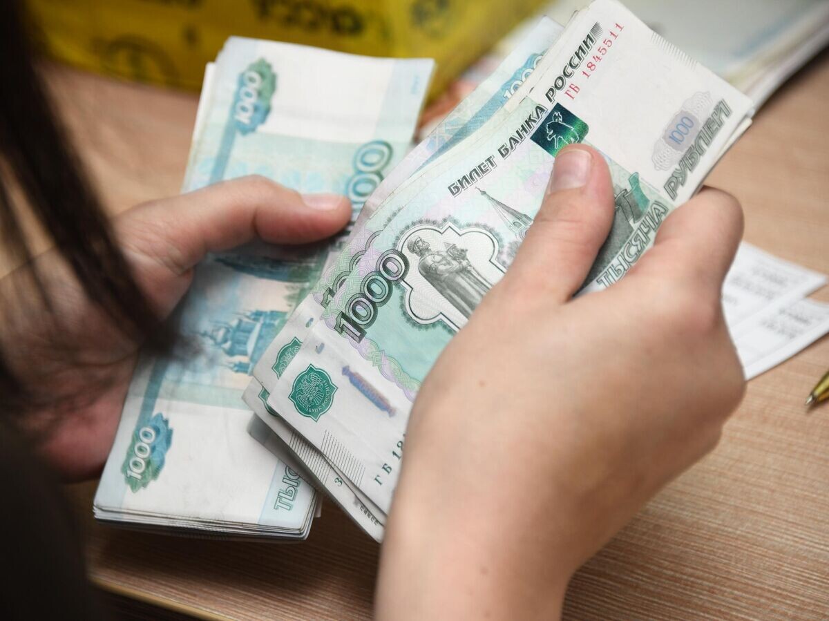    Работник почтамта пересчитывает деньги© РИА Новости / Евгений Епанчинцев