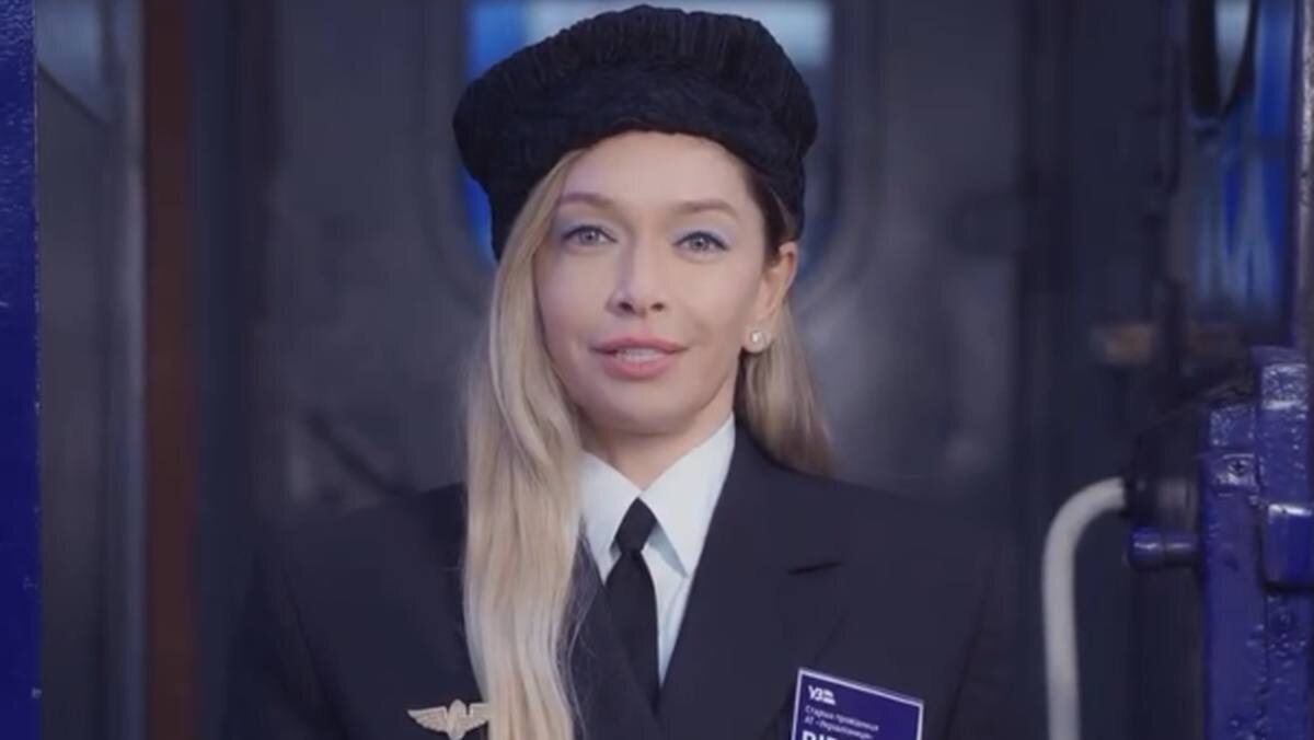 Певице накрасили голубые тени, поэтому она стала ещё больше похожа на проводницу. Фото: скриншот из видео