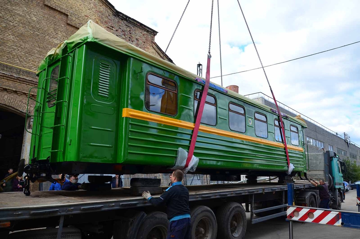 "Процесс реставрации старинного вагона: транспортировка после восстановительных работ"