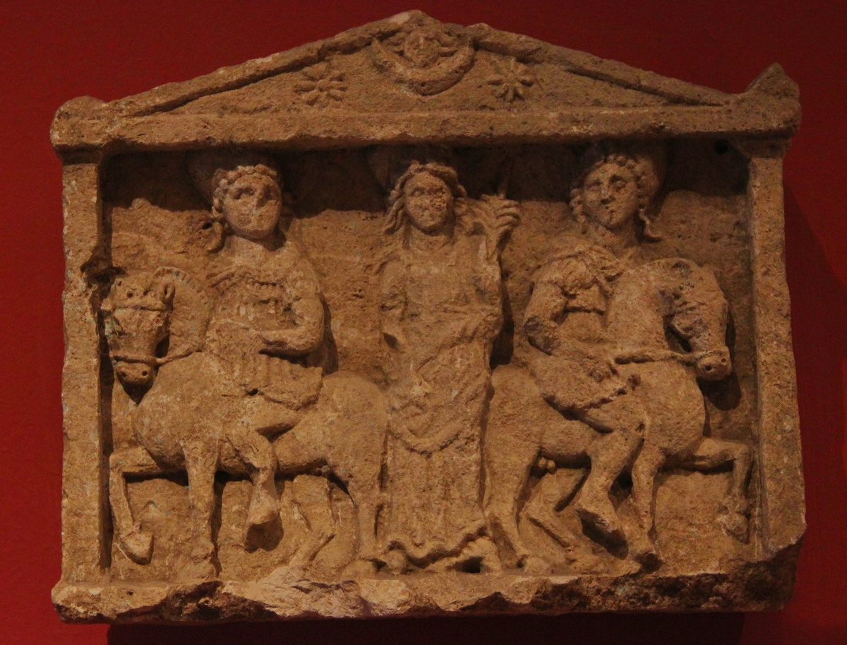Всадники и Дева из музея Антальи, I-III вв.  Вверху, на фронтоне, та же сцена представлена аниконически, в виде астральных символов.