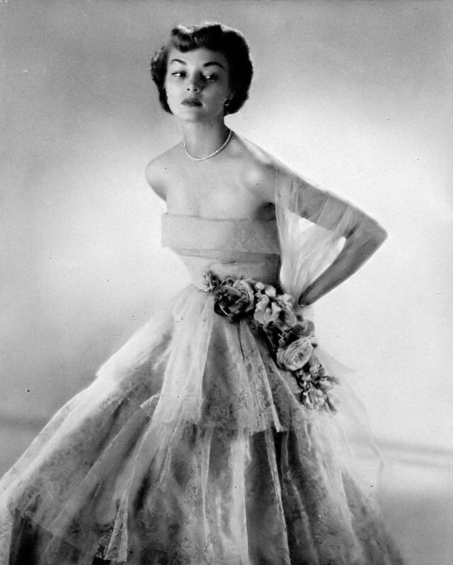 Джин Пэтчетт в нежно-голубом кружевном платье с многослойной юбкой от Омара Киама для Ben Reig в Neiman Marcus, Harper's Bazaar, октябрь 1948 г.