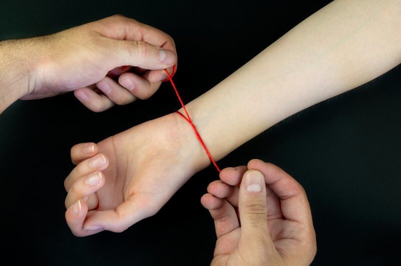 Завяжите красную шерстяную нить на левое запястье на три узла. Фото из интернета