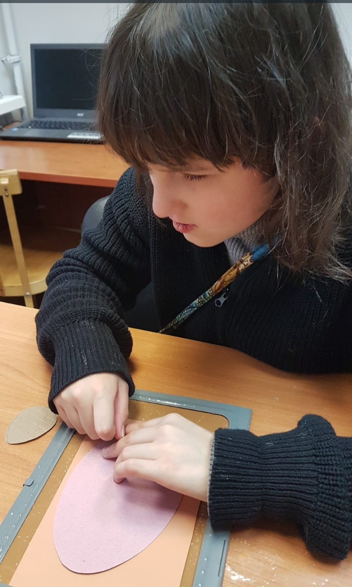 Ребенок незрячий,накалывает по трафарету контур 