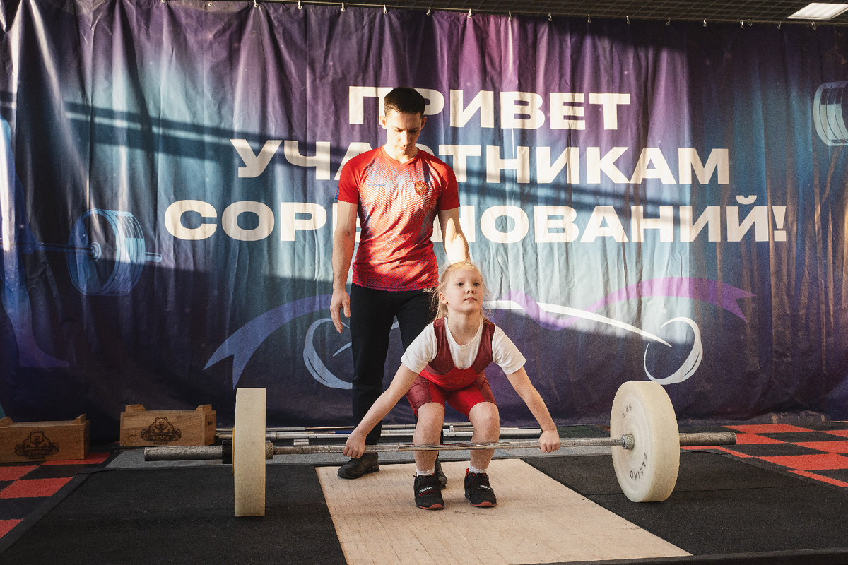 Маленькая, но уже по-спортивному крепкая и очень техничная София Соколова запросто поднимает
практически свой вес, установленный на штанге. 