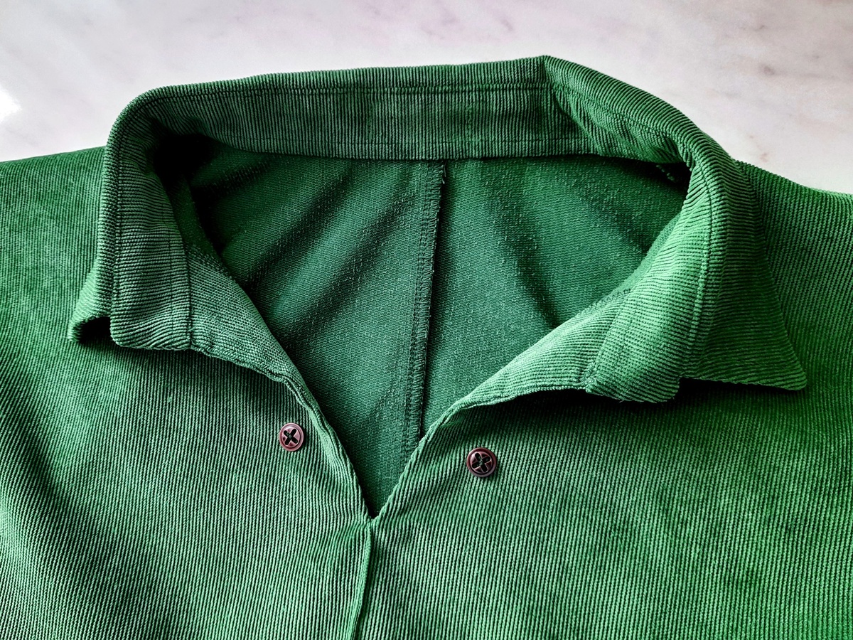 Металлические пуговицы под бронзу, пришитые к воротнику зелёного платья из микровельвета.