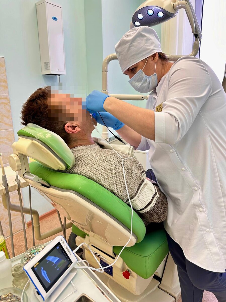 Врач стоматолог-терапевт Марина Зимина лечит зуб пациенту с применением апекслокатора