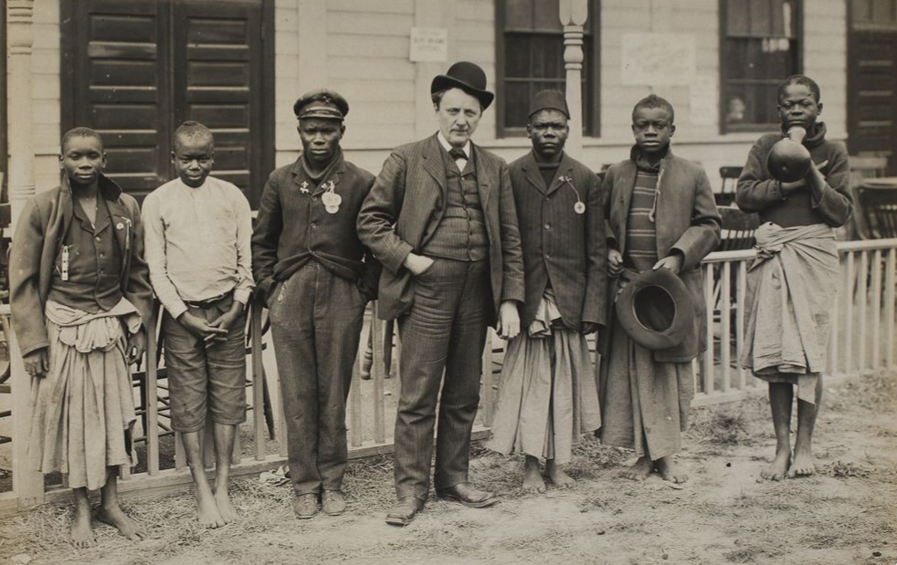 Сэмюэл Филлипс Вернер (в центре) со случайными африканцами, которых он купил у работорговцев для Луизианской выставки 1904 года и выдал за «пигмеев» на Всемирной выставке.