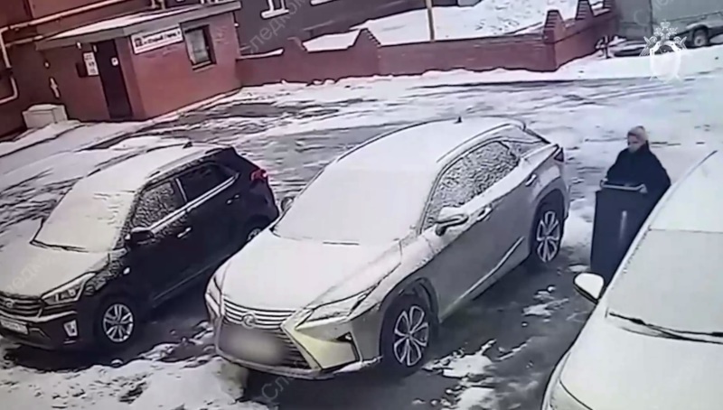    Тархова выносит бочку, предположительно, с останками близких. Фото: СКР