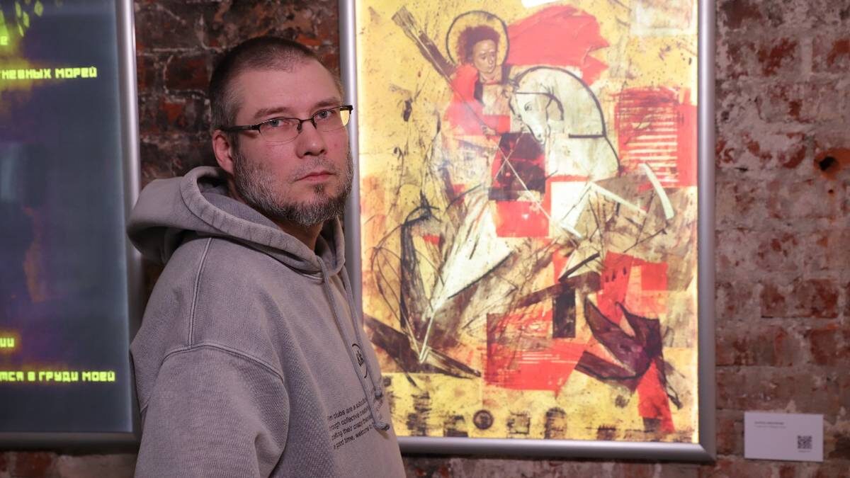    Художник Антон Беликов рядом со своей картиной «Георгий Победоносец» на выставке «Тут совсем не так, как в твоих розовых очках» / Фото: Анатолий Цымбалюк / Вечерняя Москва